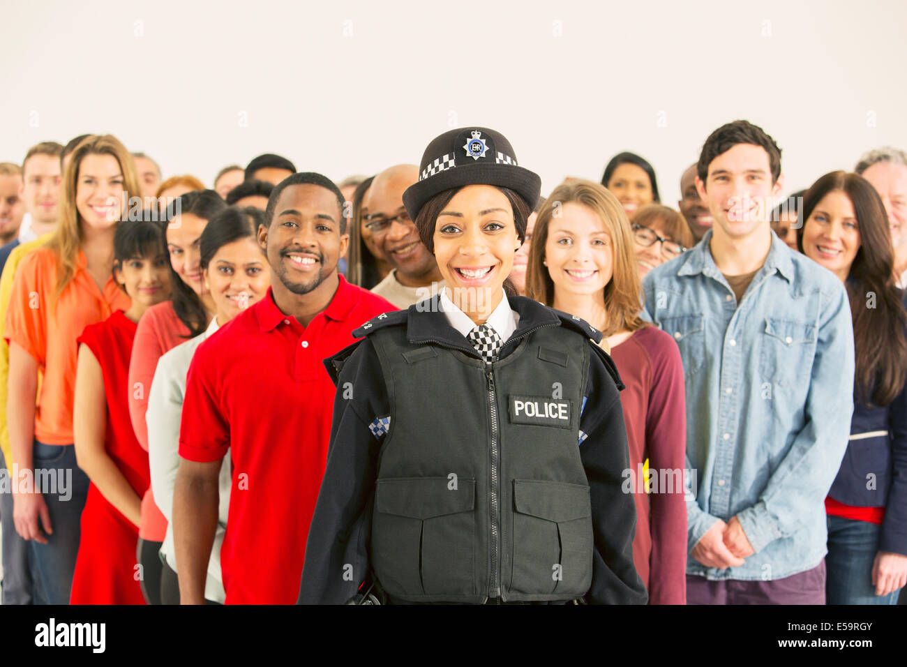 Portrait of smiling policewoman in front of large crowd Stock Photo