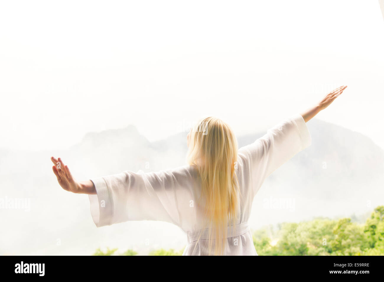 Woman in bathrobe overlooking landscape Stock Photo