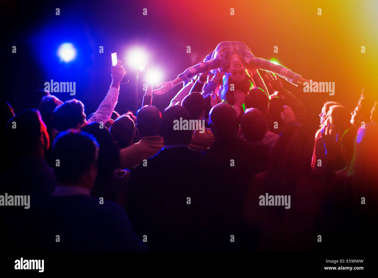 Woman crowd surfing at concert Stock Photo