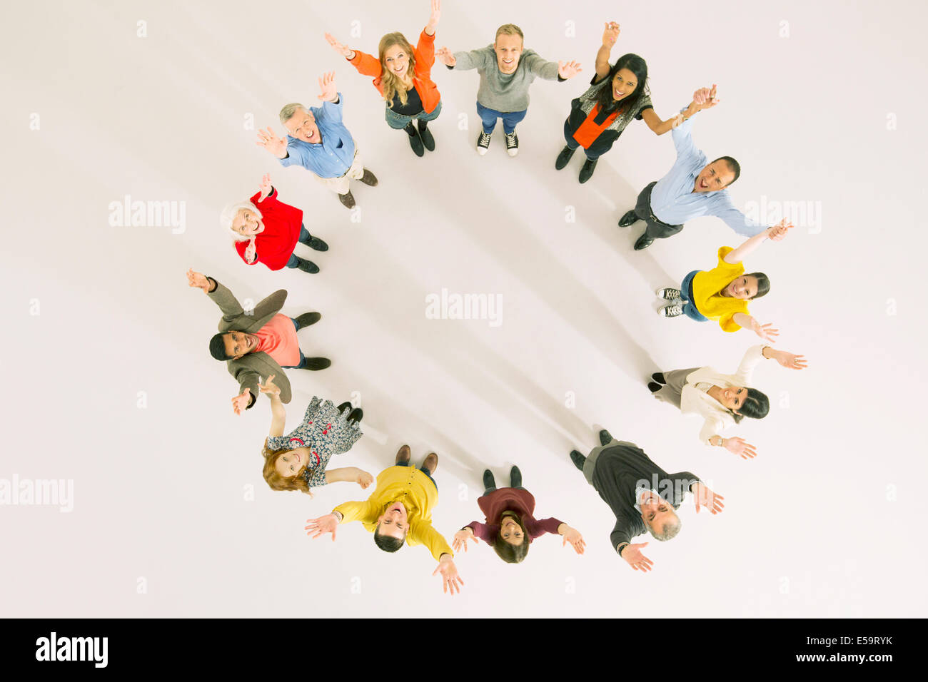 Business people with arms raised in circle Stock Photo