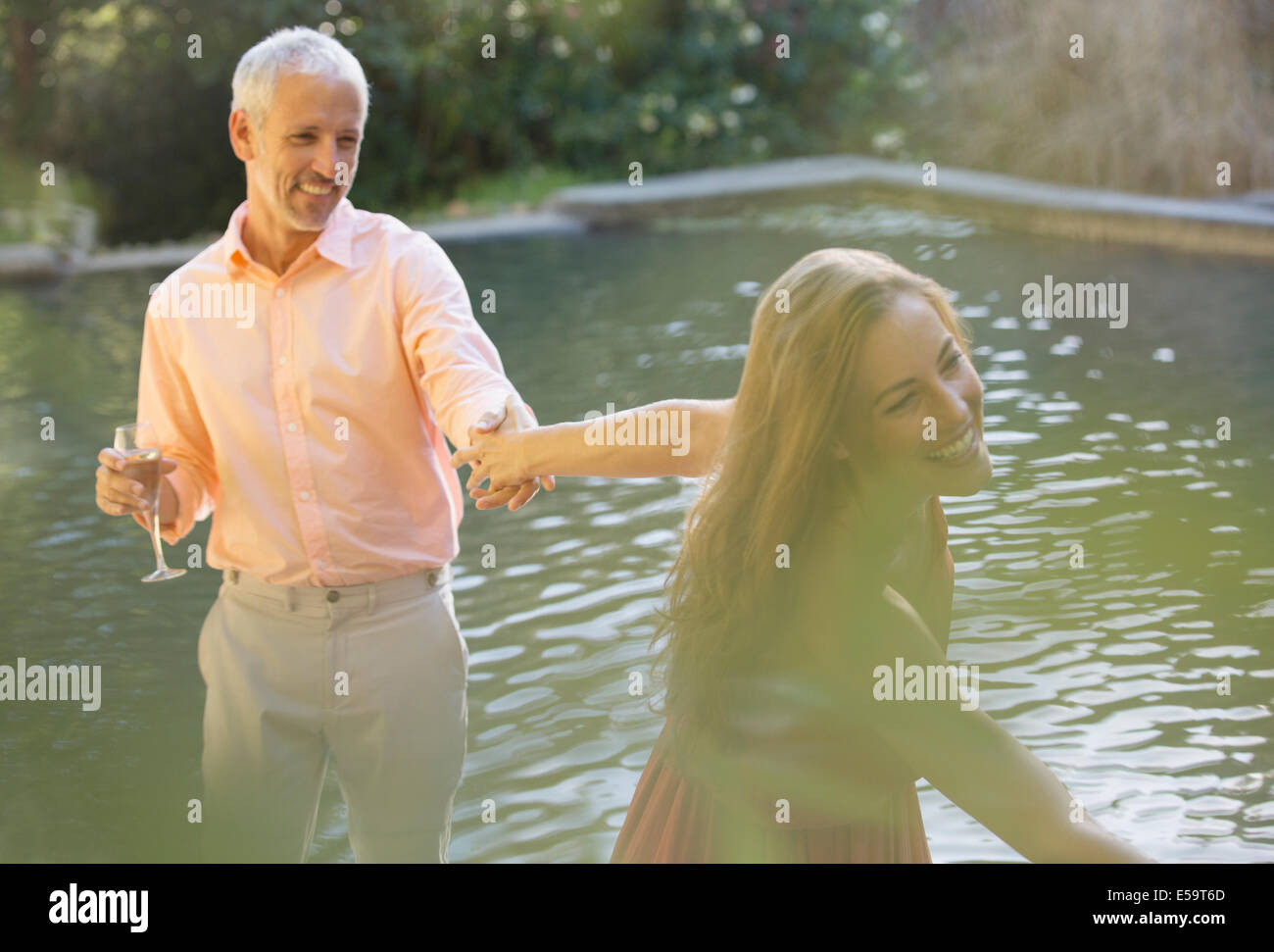 Couple holding hands by pool outdoors Stock Photo Alamy