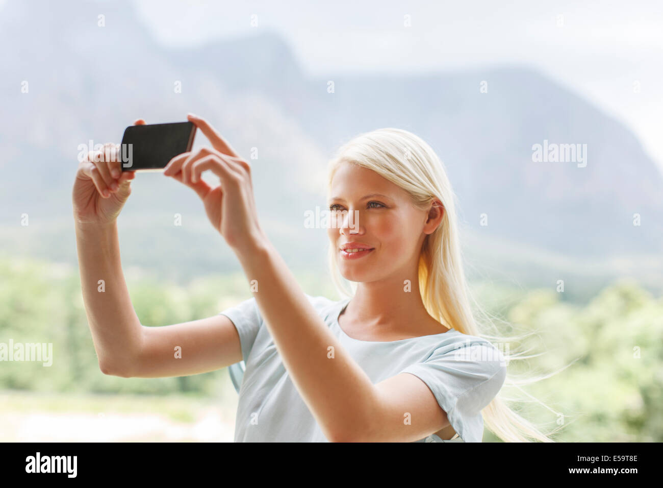 Woman taking pictures in rural landscape Stock Photo
