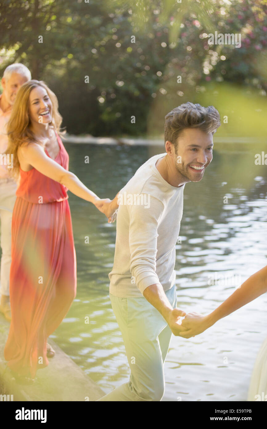 Friends holding hands by pool Stock Photo Alamy
