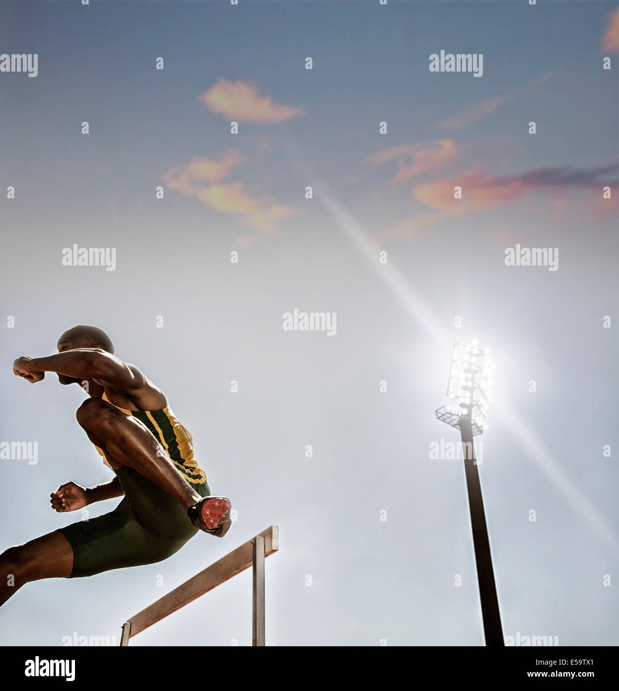 Track and field athlete clearing hurdle Stock Photo