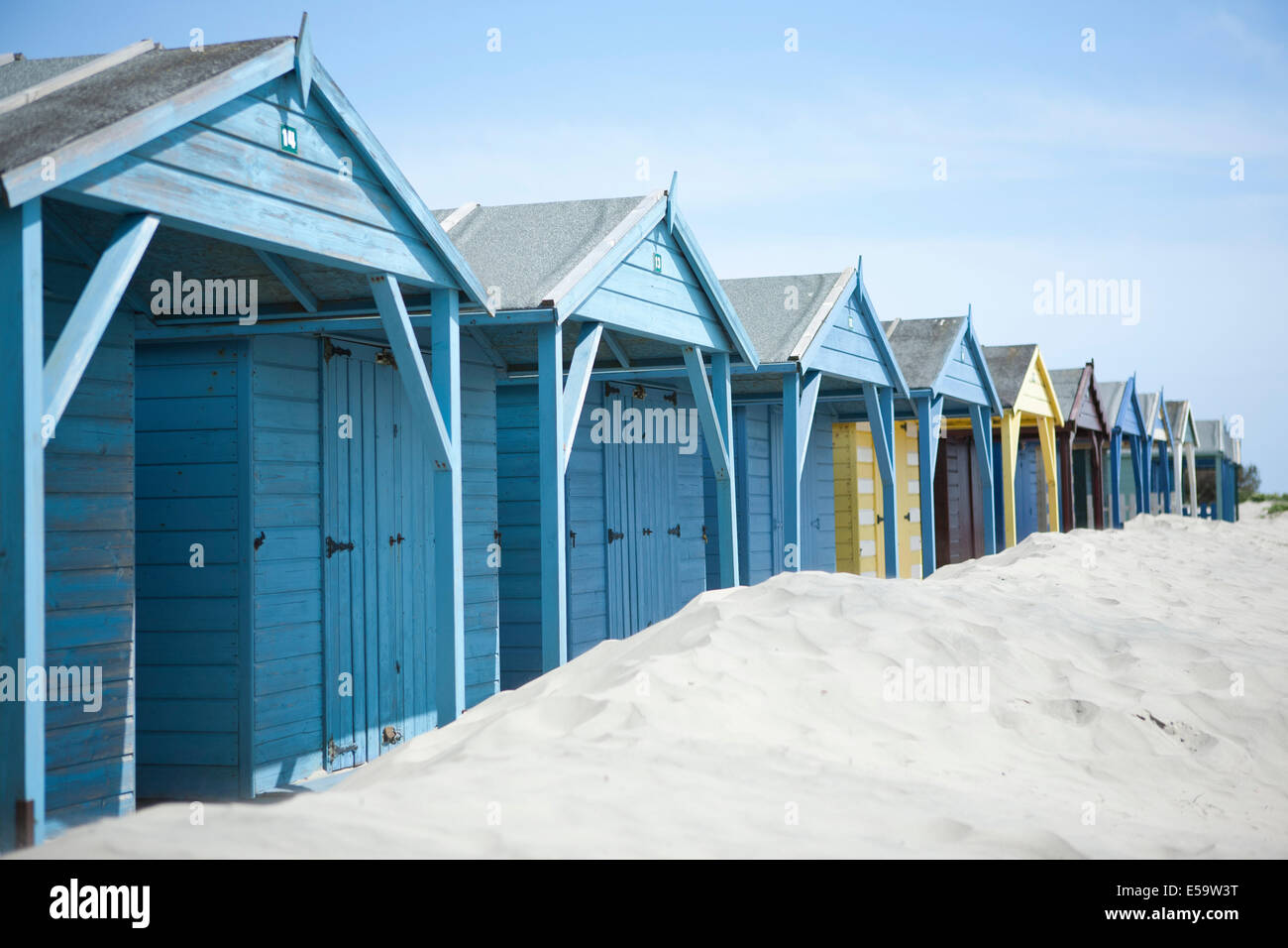 wooden painted colourful beach huts sand dunes West Wittering Sussex coast Stock Photo