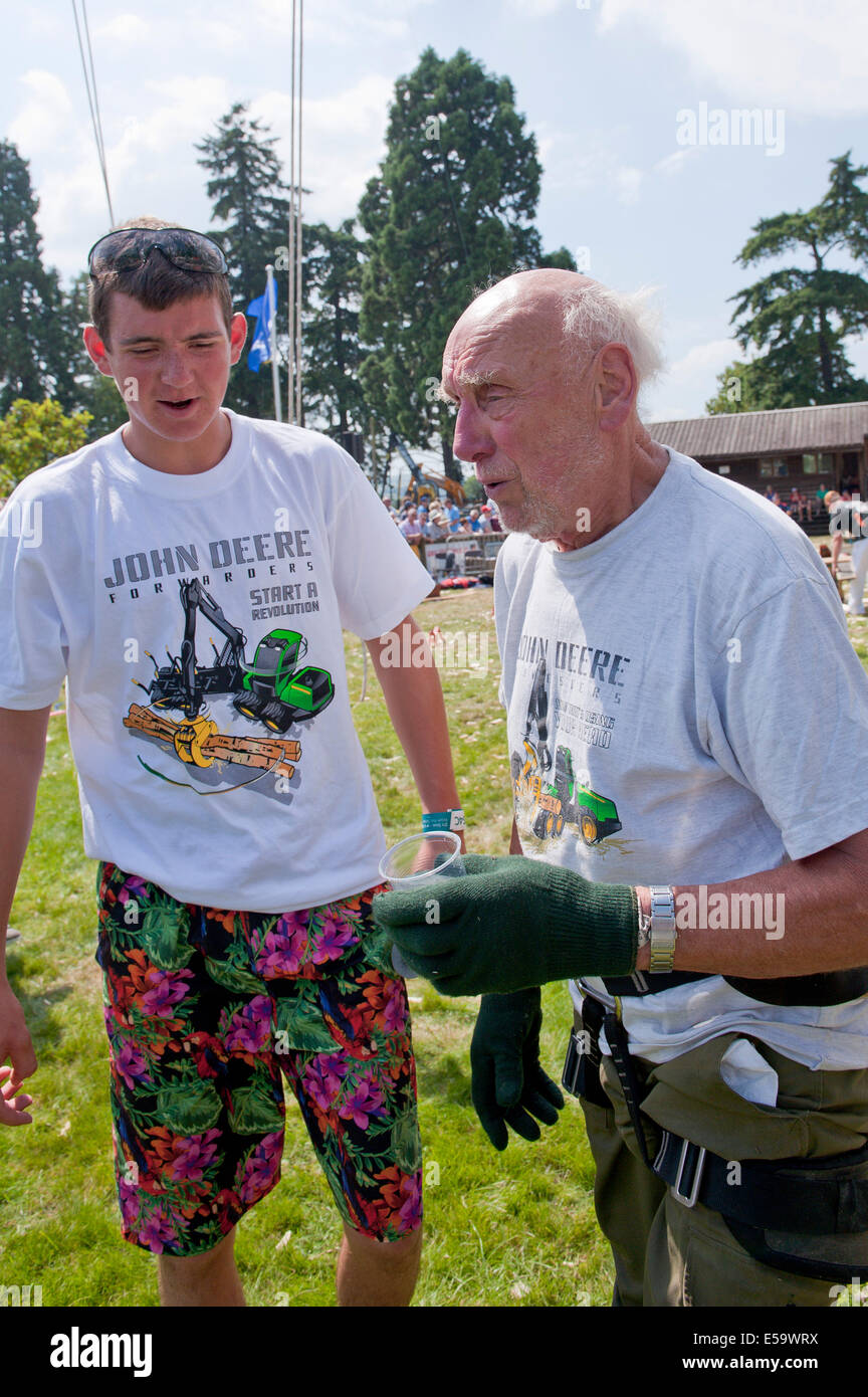 Llanelwedd, UK. 23rd July 2014. 81-year-old George Tipping from Liverpool with his grandson Daniel Whelan 17 after George's climb up the 100 feet (30.48 Meters) pole  in the Forestry Area.  Record numbers of visitors in excess of 240,000 are expected this week over the four day period of Europe’s largest agricultural show. Livestock classes and special awards have attracted 8,000 plus entries, 670 more than last year. The first ever Royal Welsh Show was at Aberystwyth in 1904 and attracted 442 livestock entries. Credit:  Graham M. Lawrence/Alamy Live News. Stock Photo