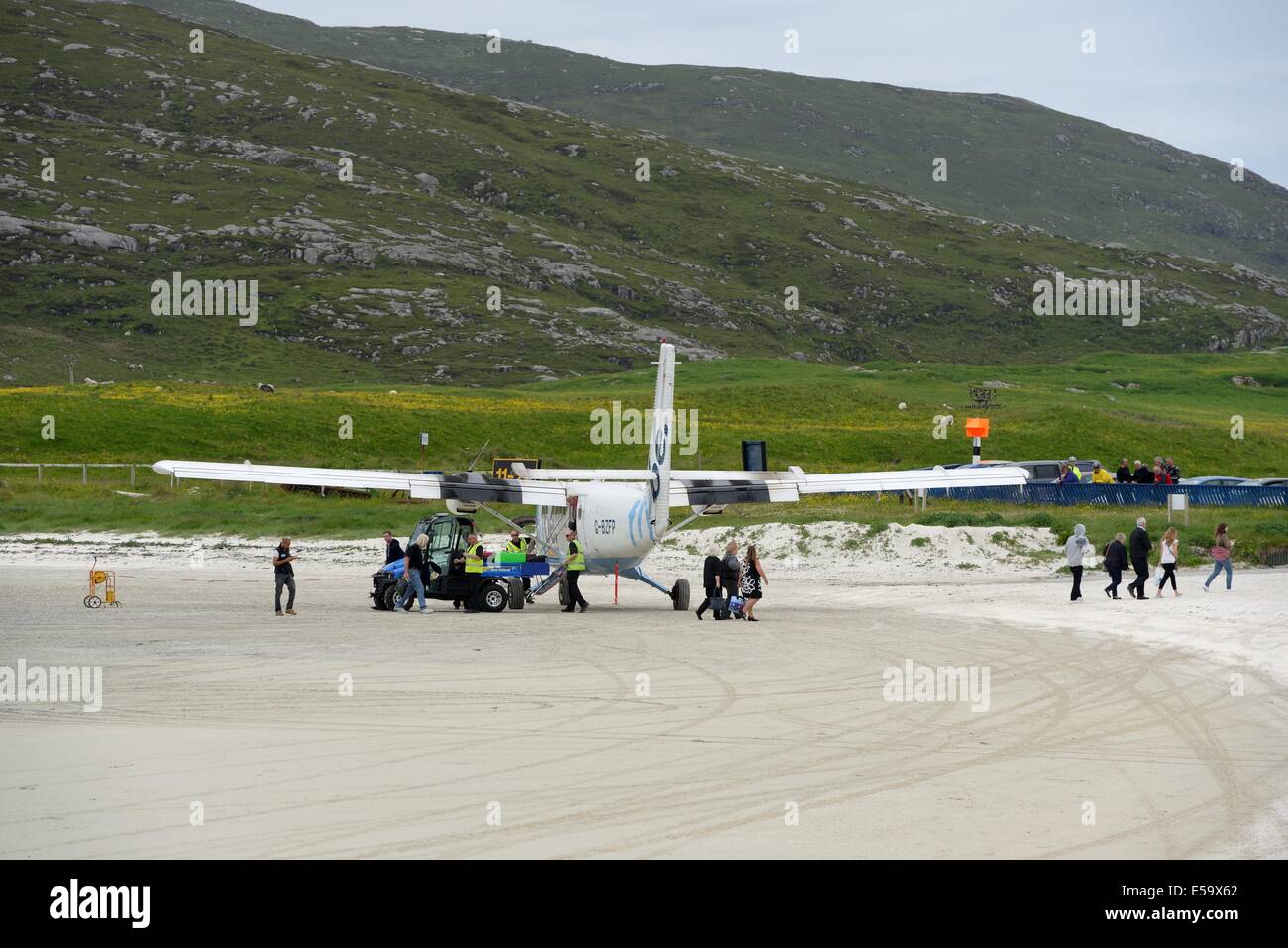 Passengers disembarking the aircraft which has just landed on the beach at Barra airport in the Outer Hebrides, in Scotland Stock Photo