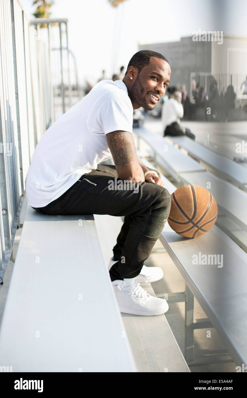 African American man sitting in bleachers Stock Photo