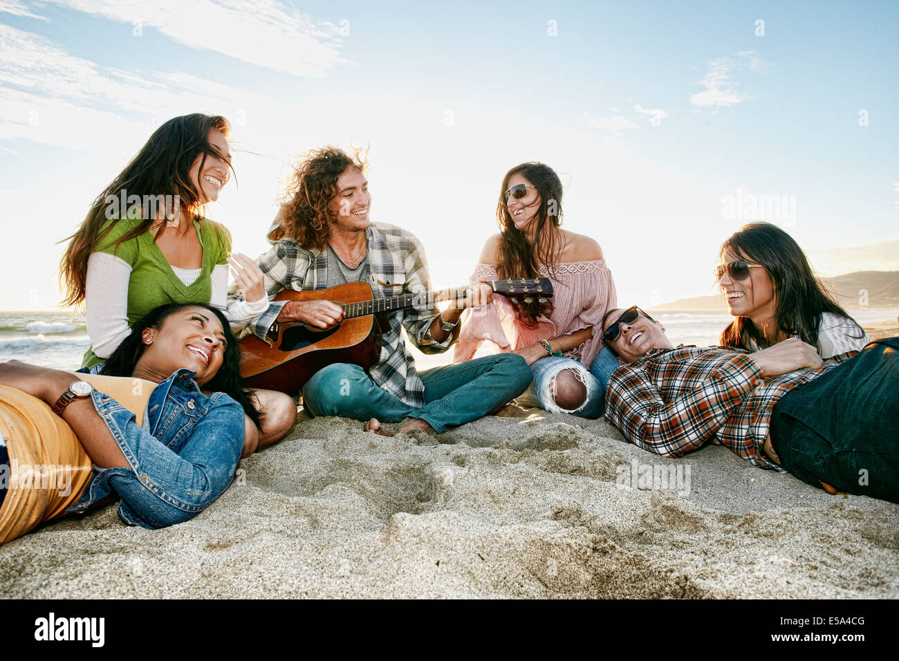 Friends relaxing together on beach Stock Photo