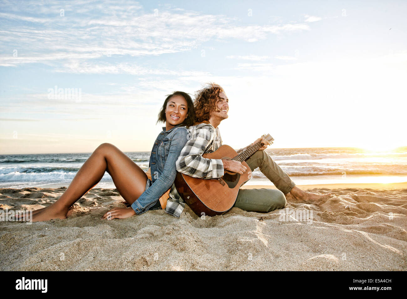 Couple relaxing together on beach Stock Photo