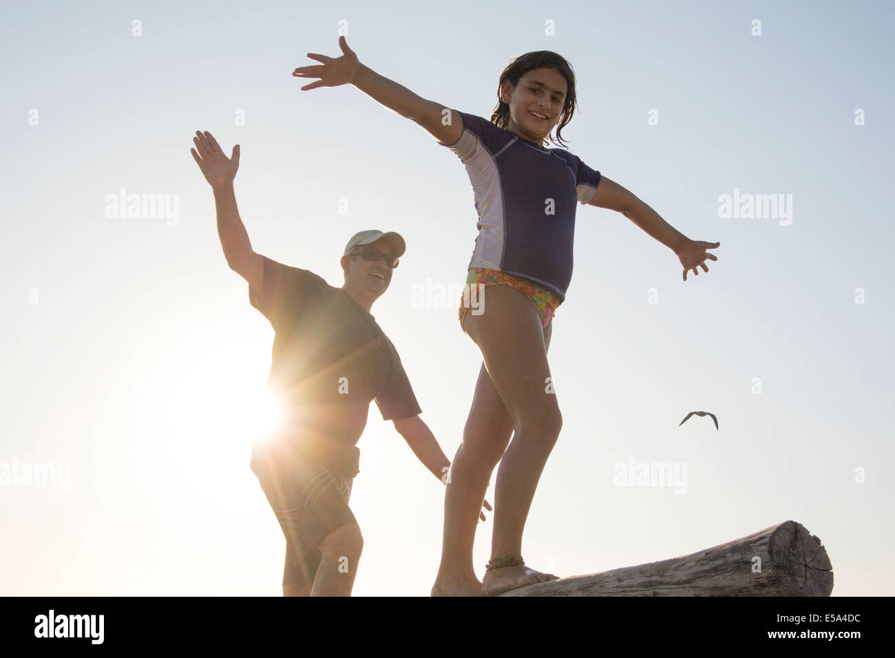 Father and daughter balancing on log Stock Photo