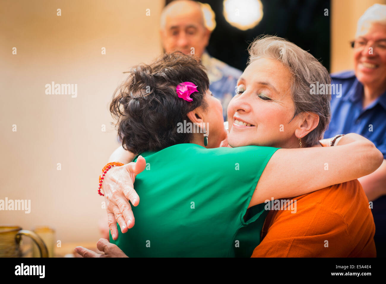 Hispanic women hugging in restaurant Stock Photo - Alamy