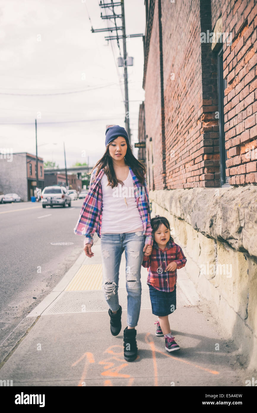 Korean mother and daughter holding hands on city street Stock Photo