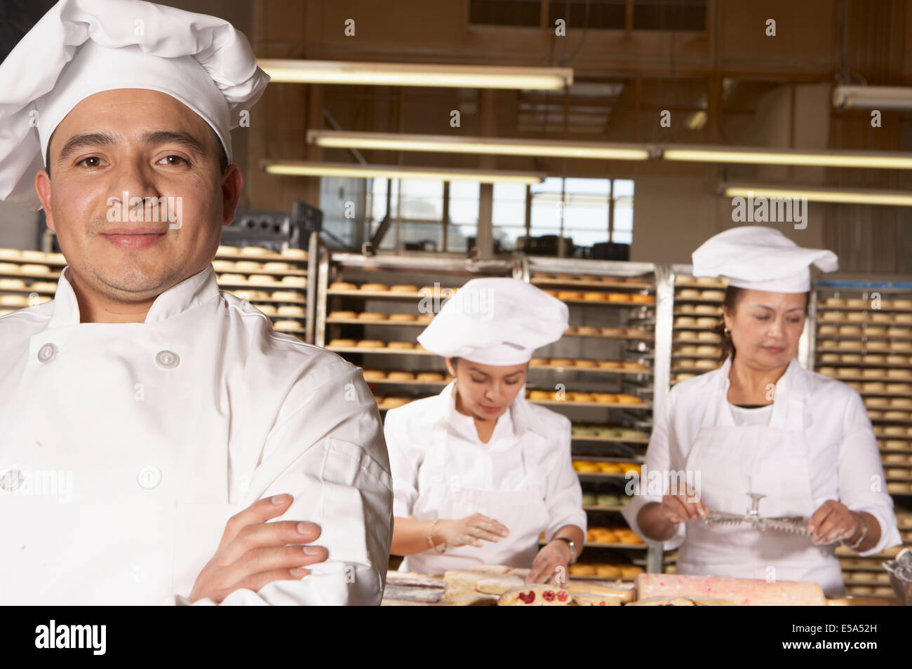 Hispanic bakers working in bakery Stock Photo