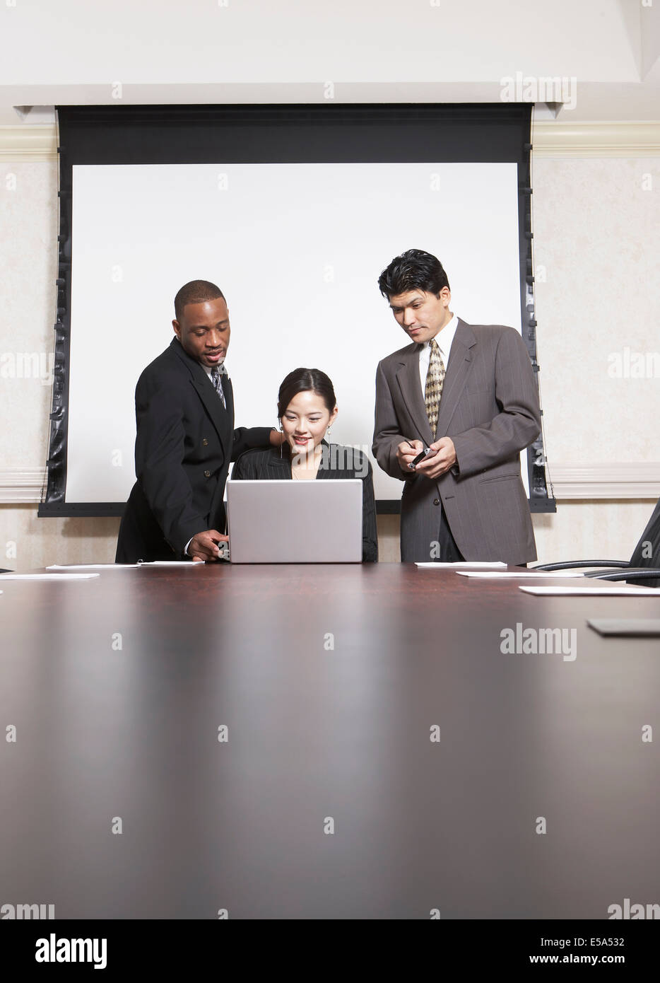 Business people using laptop at conference table Stock Photo