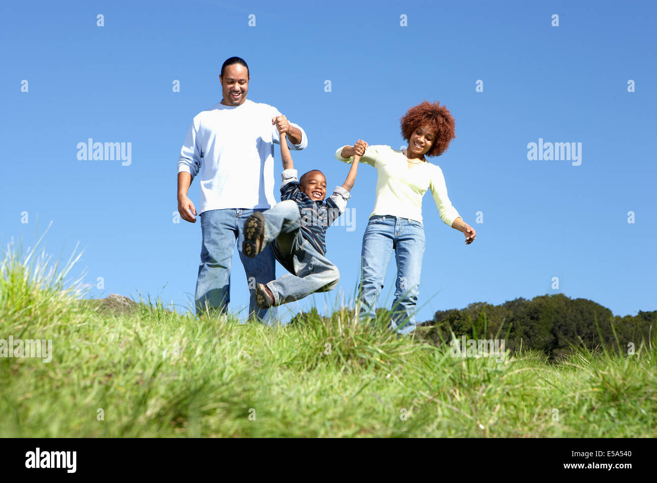 African American family walking together in field Stock Photo