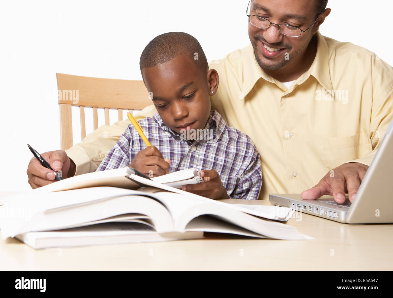 African American father helping son with homework Stock Photo