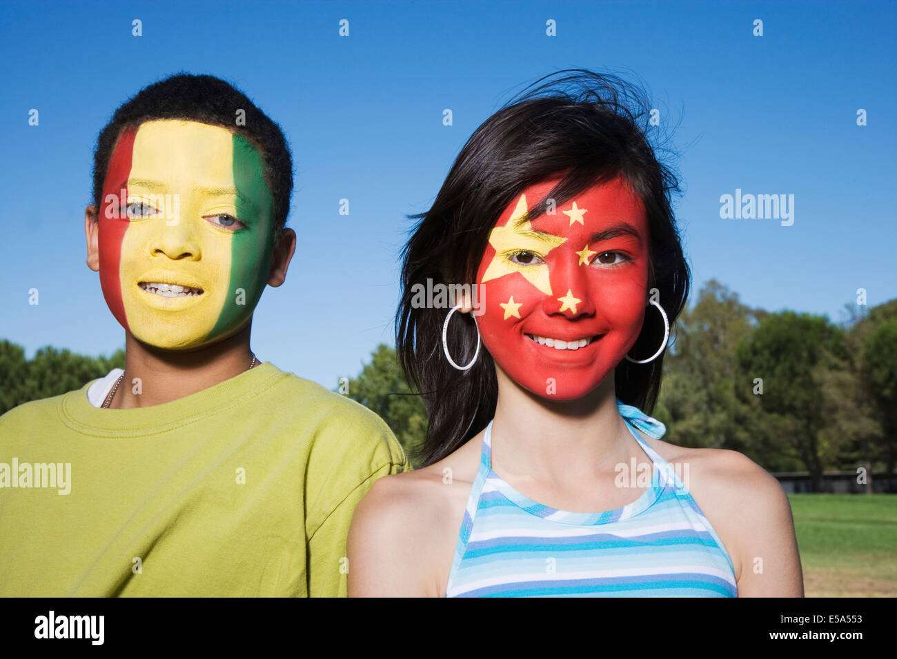 Children with Guinean and Chinese flags painted on faces Stock Photo