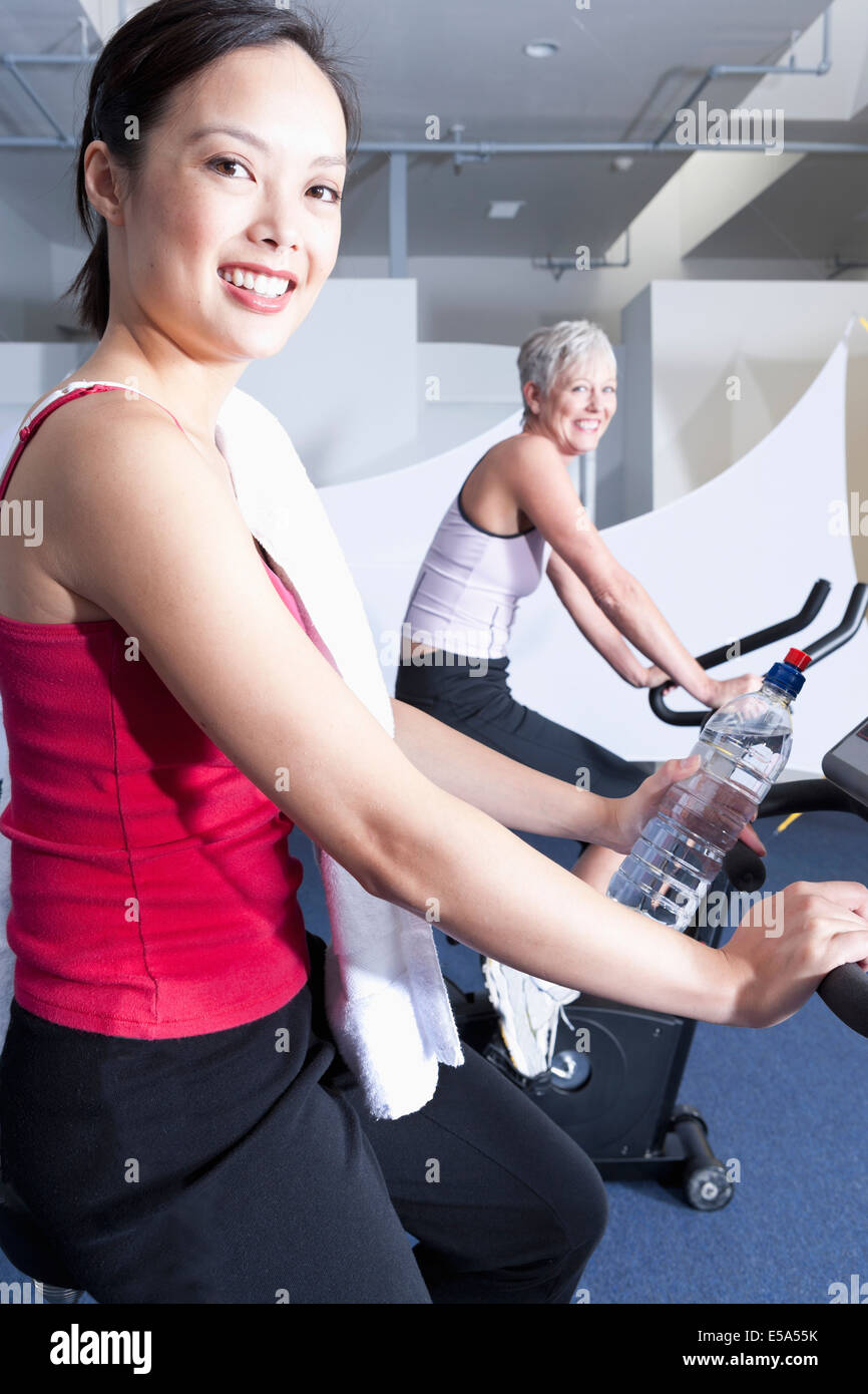 Women using exercise machines in gym Stock Photo