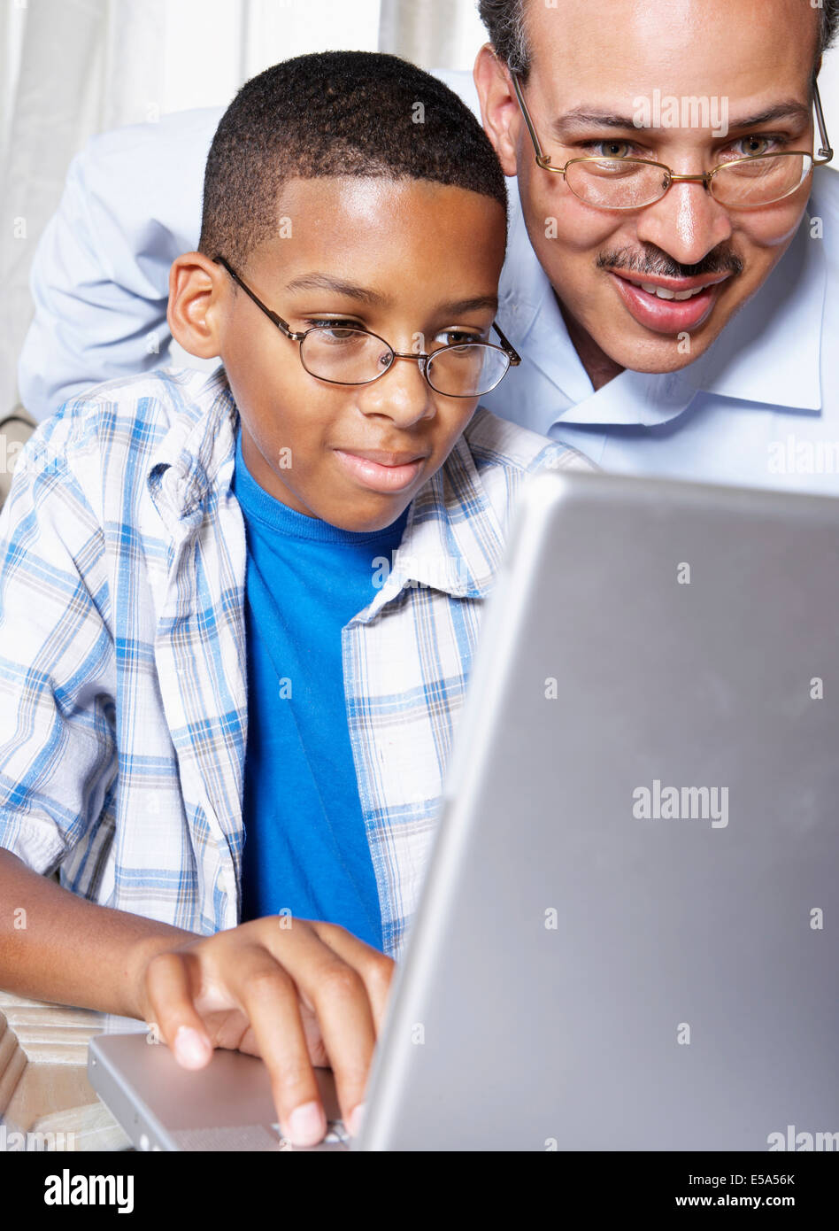 Father and son using laptop together Stock Photo