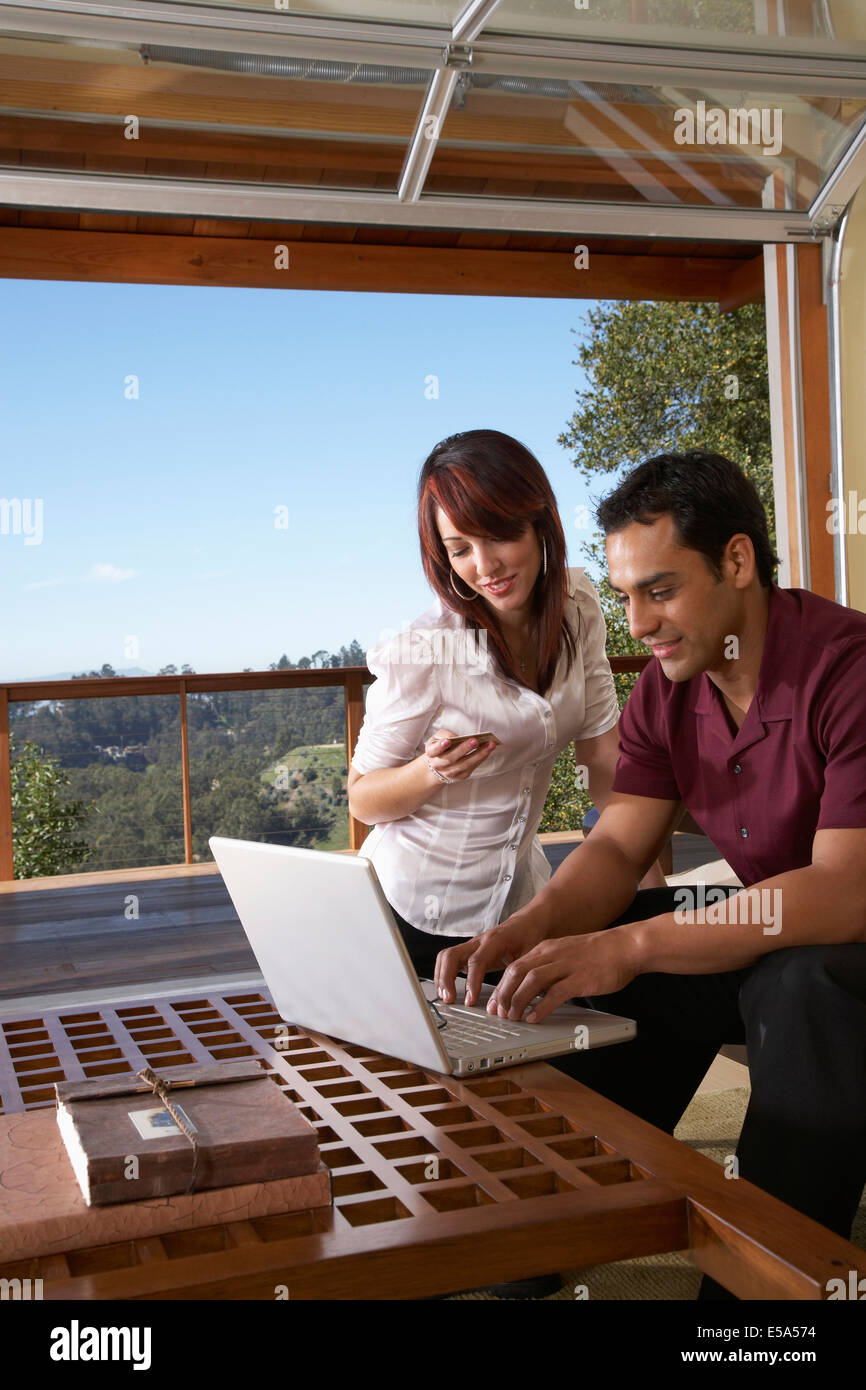 Hispanic couple using laptop together Stock Photo