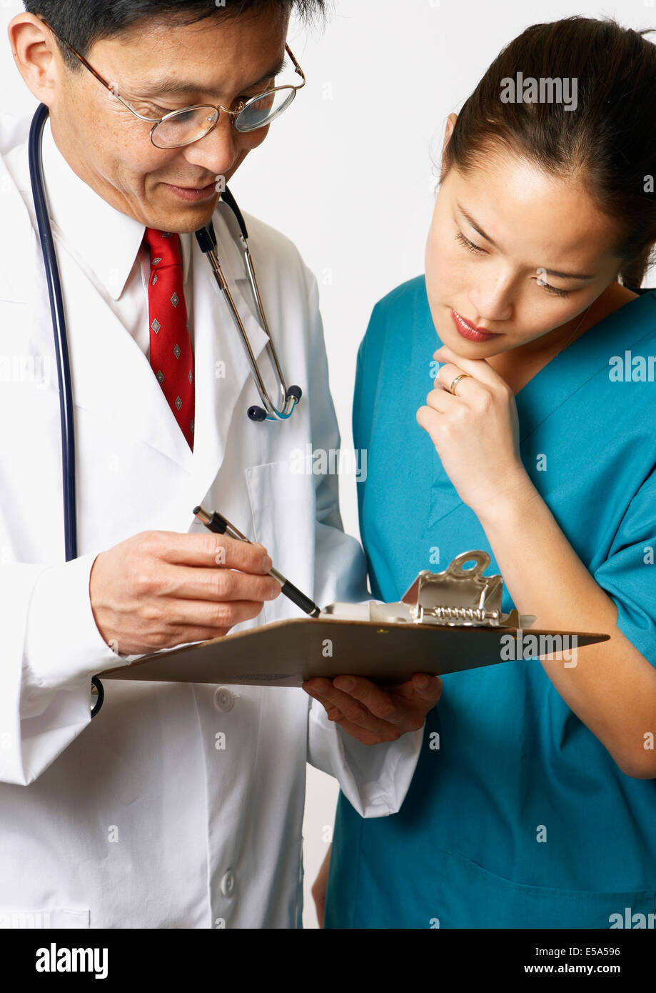 Doctor and nurse reading medical charts together Stock Photo