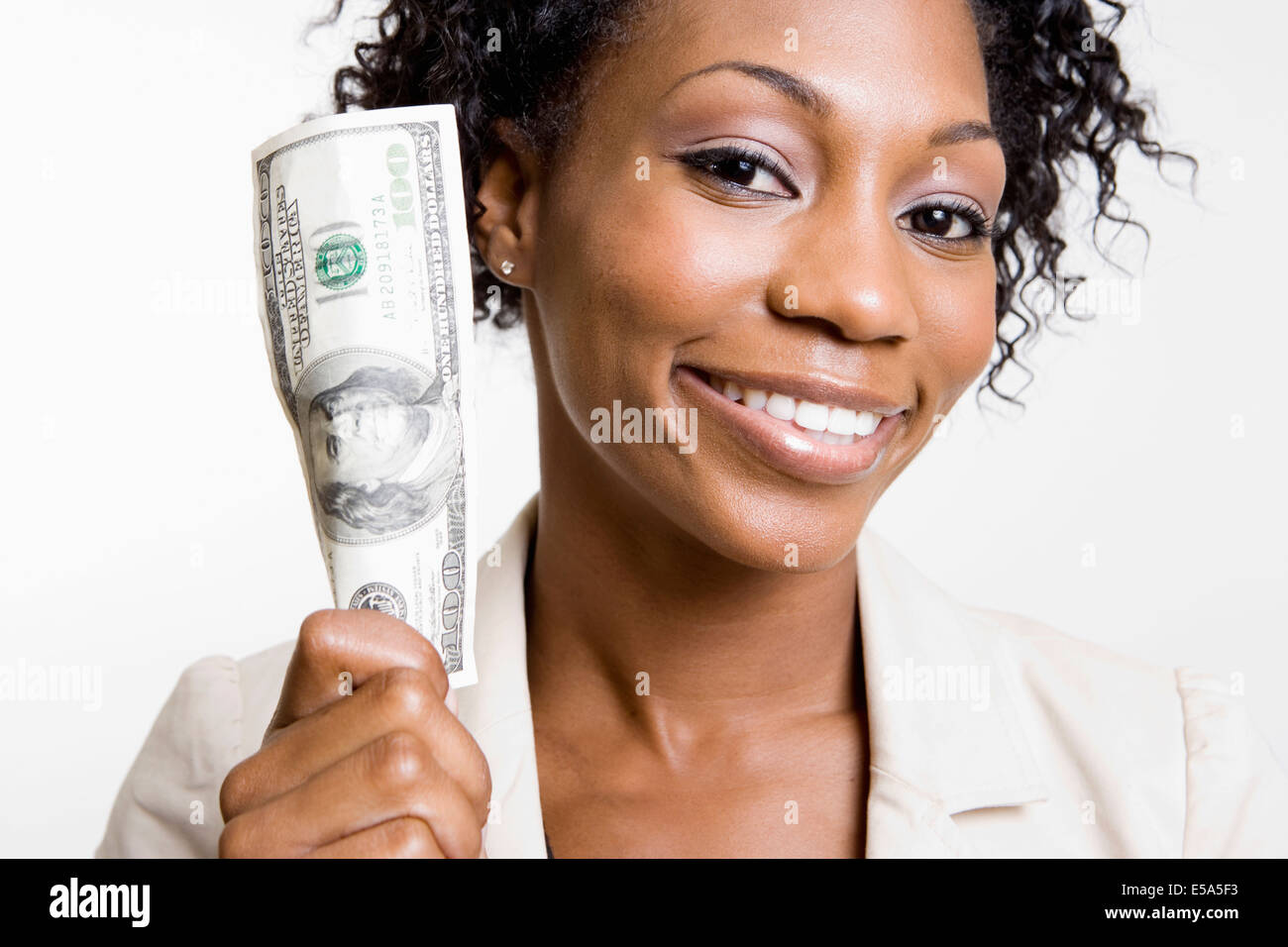 African American woman holding hundred dollar bill Stock Photo