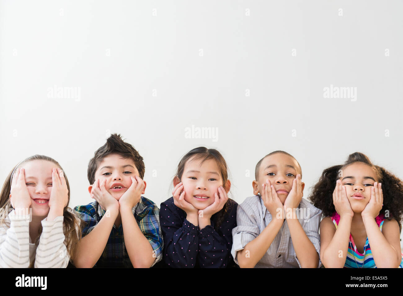 Children resting chins in hands Stock Photo