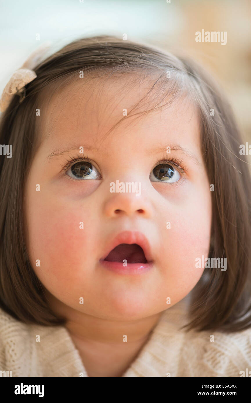 Hispanic toddler with Down syndrome looking up Stock Photo