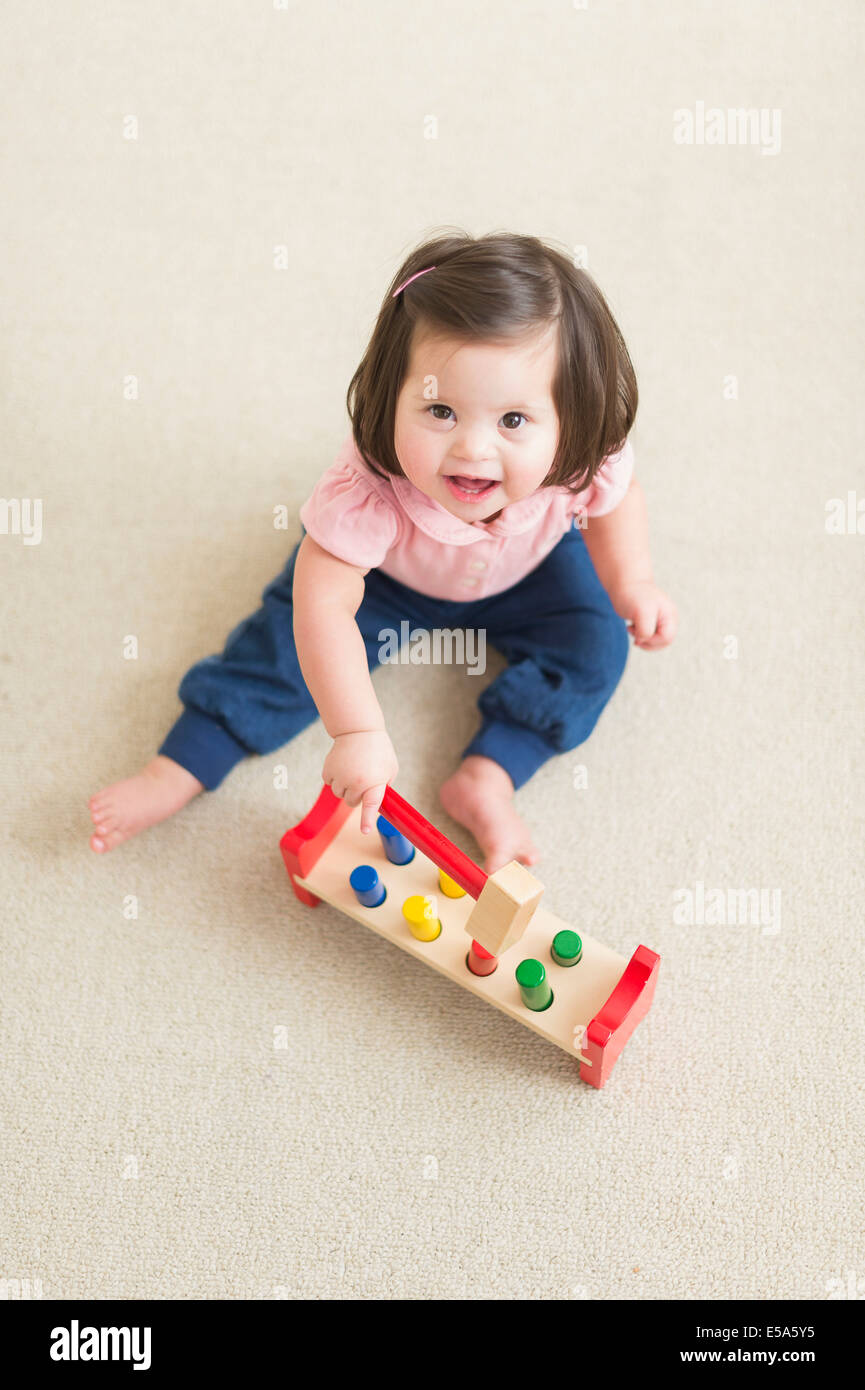 Hispanic toddler with Down syndrome playing Stock Photo