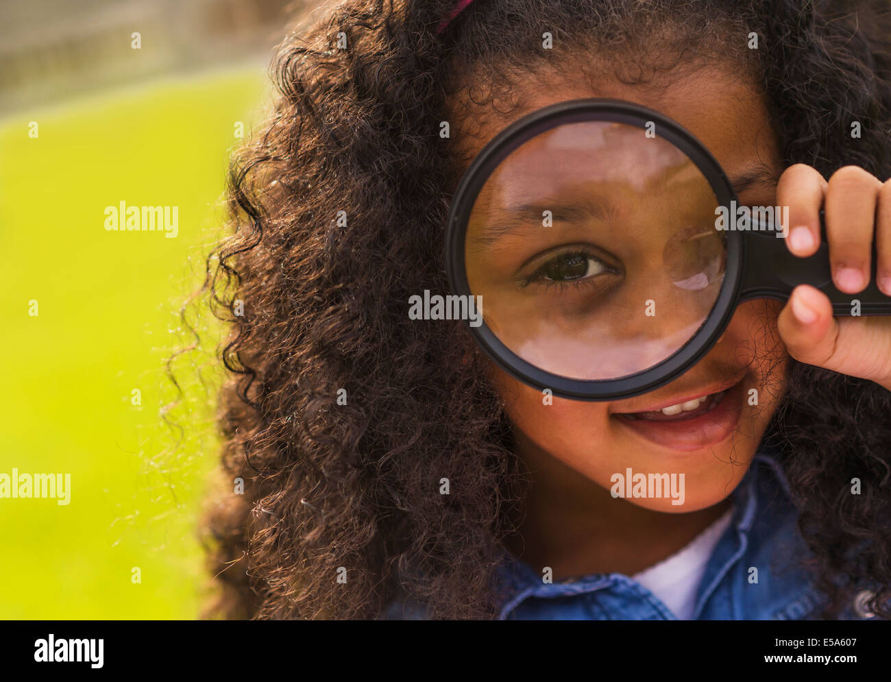 Mixed race girl using magnifying glass Stock Photo