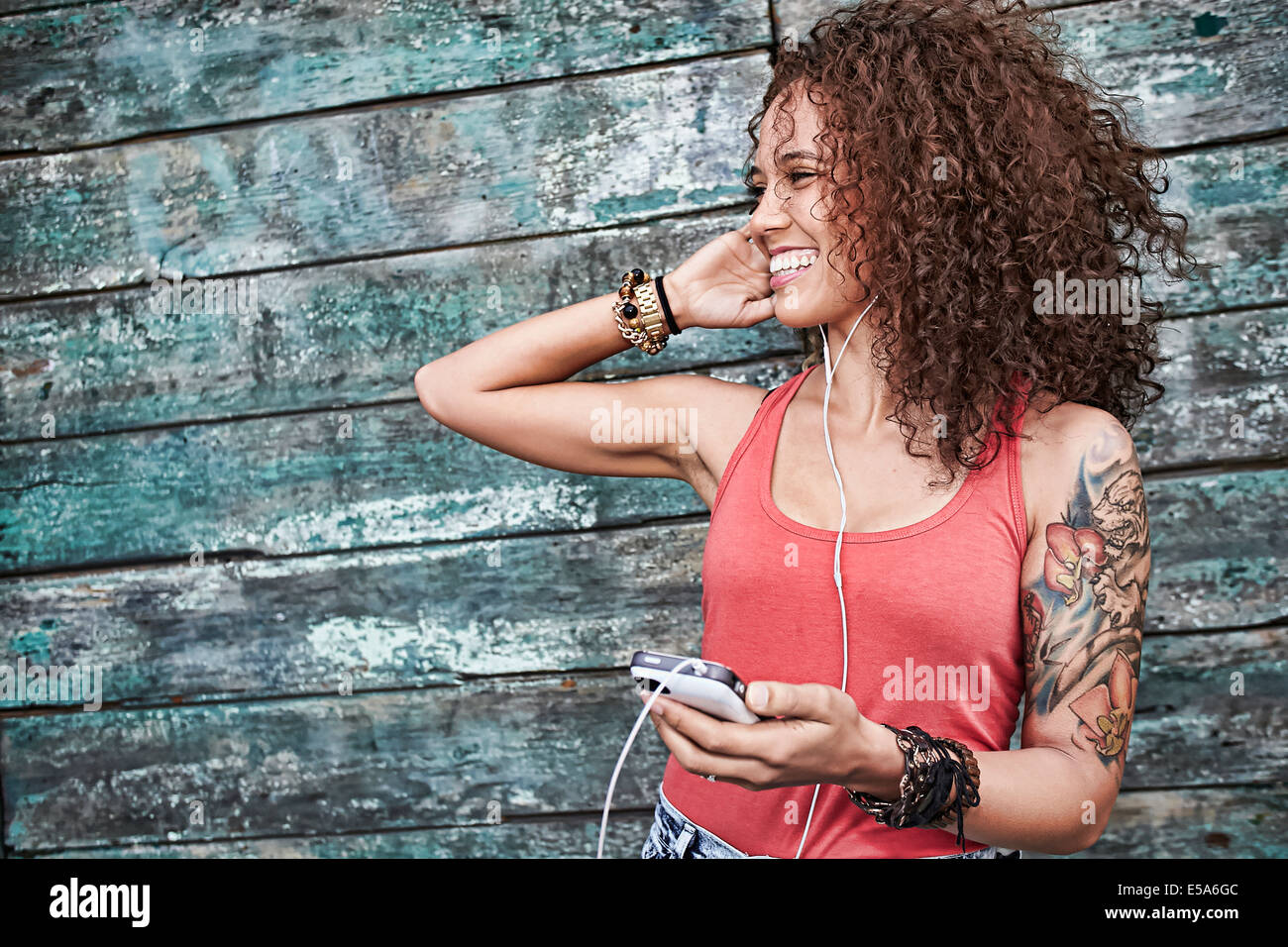 Woman listening to mp3 player on city street Stock Photo