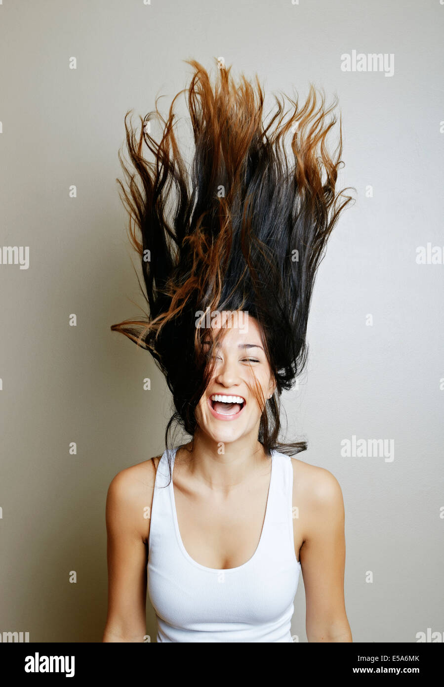 Mixed race woman tossing her hair Stock Photo