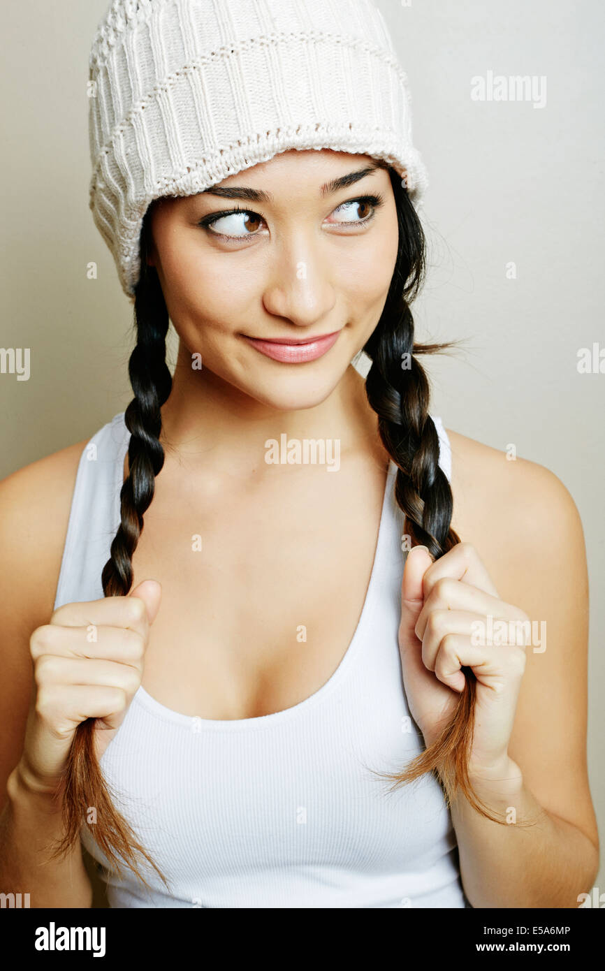 Mixed race woman pulling her pigtails Stock Photo