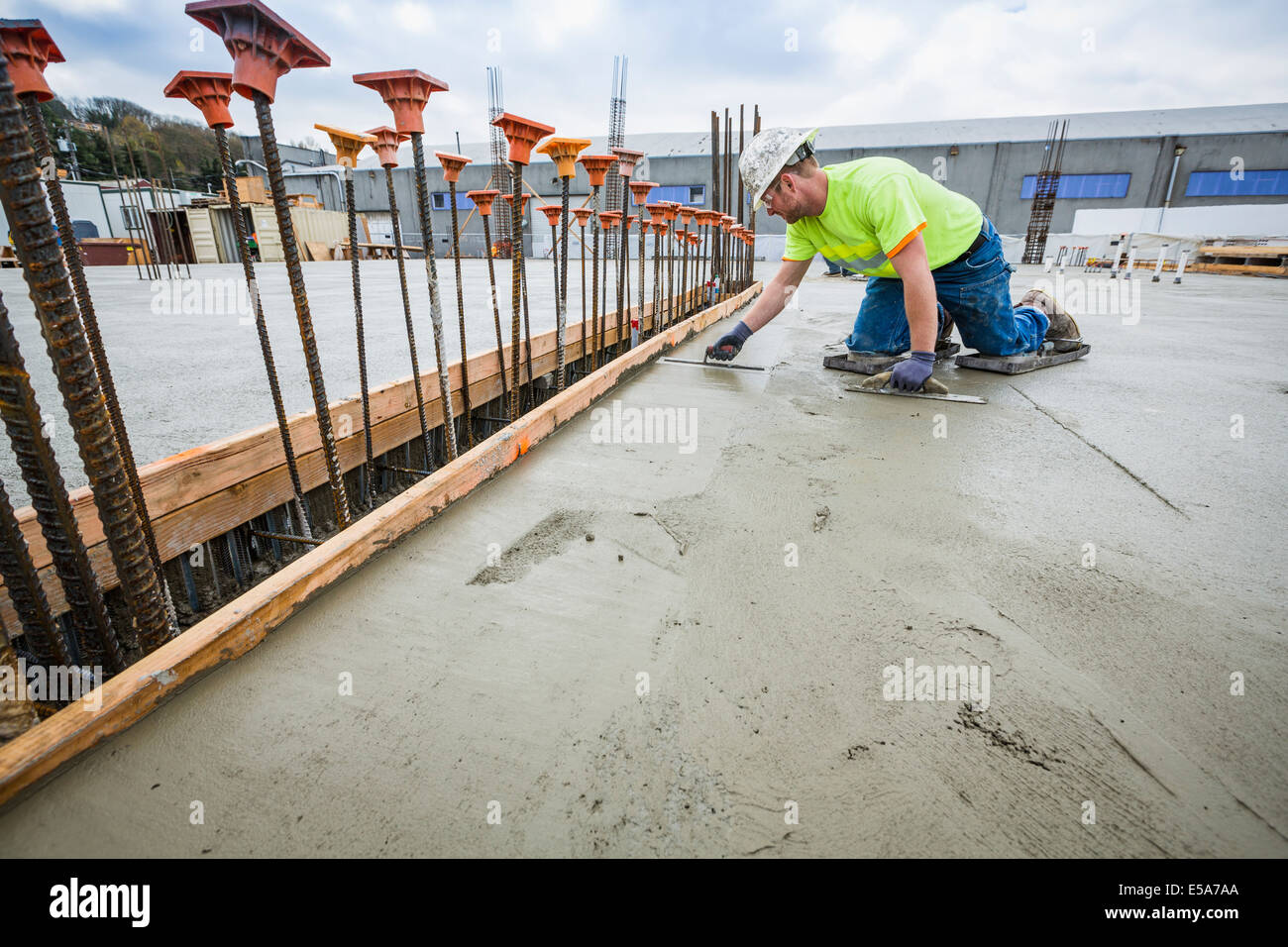 Worker finishing concrete at construction site Stock Photo
