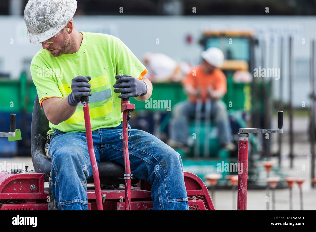 Worker operating machinery on construction site Stock Photo