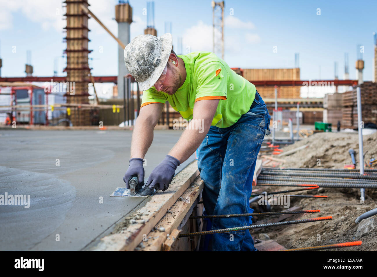 Construction worker finishing concrete at construction site Stock Photo
