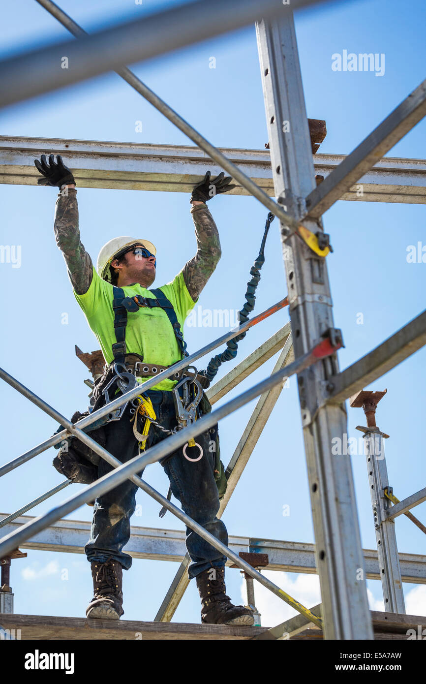 Caucasian worker on scaffolding on construction site Stock Photo