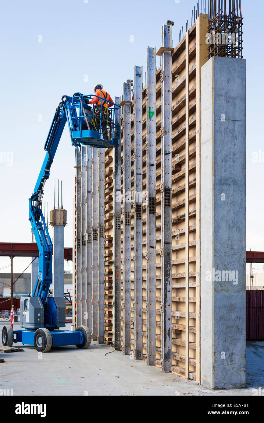 Caucasian worker on boom lift at construction site Stock Photo