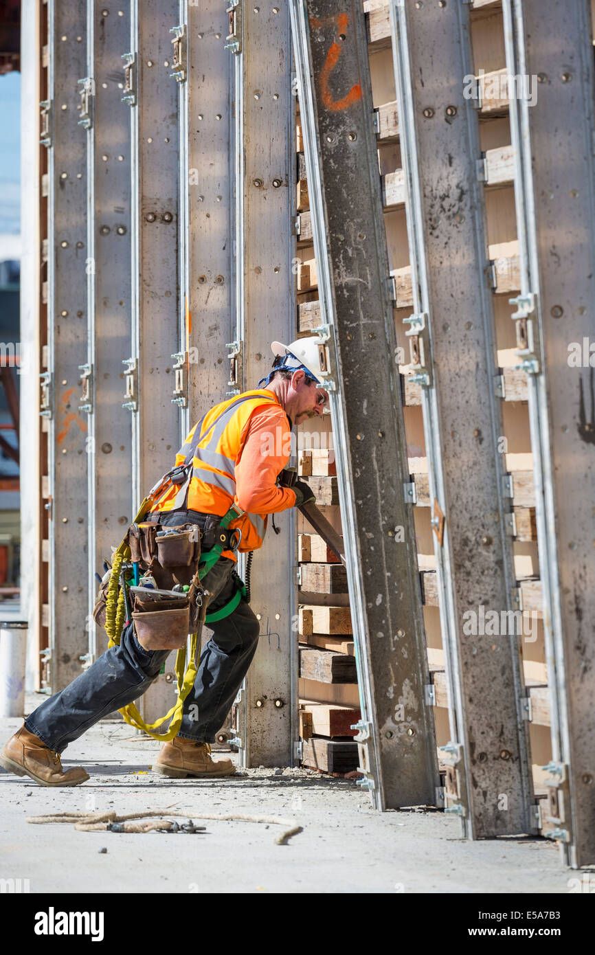 Caucasian worker pushing wall form at construction site Stock Photo