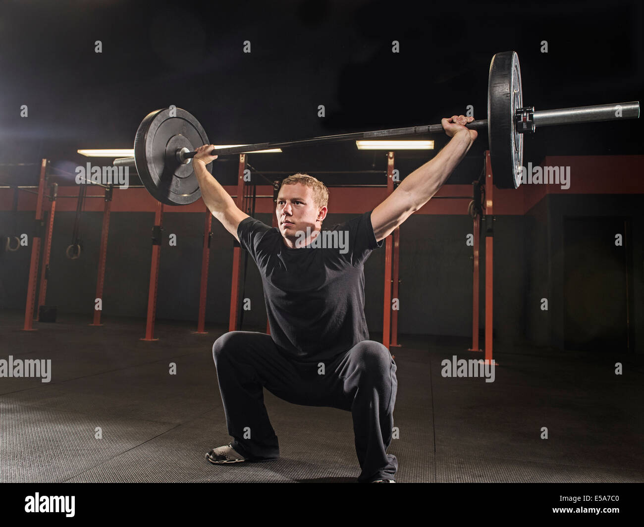 Caucasian man lifting weights in gym Stock Photo