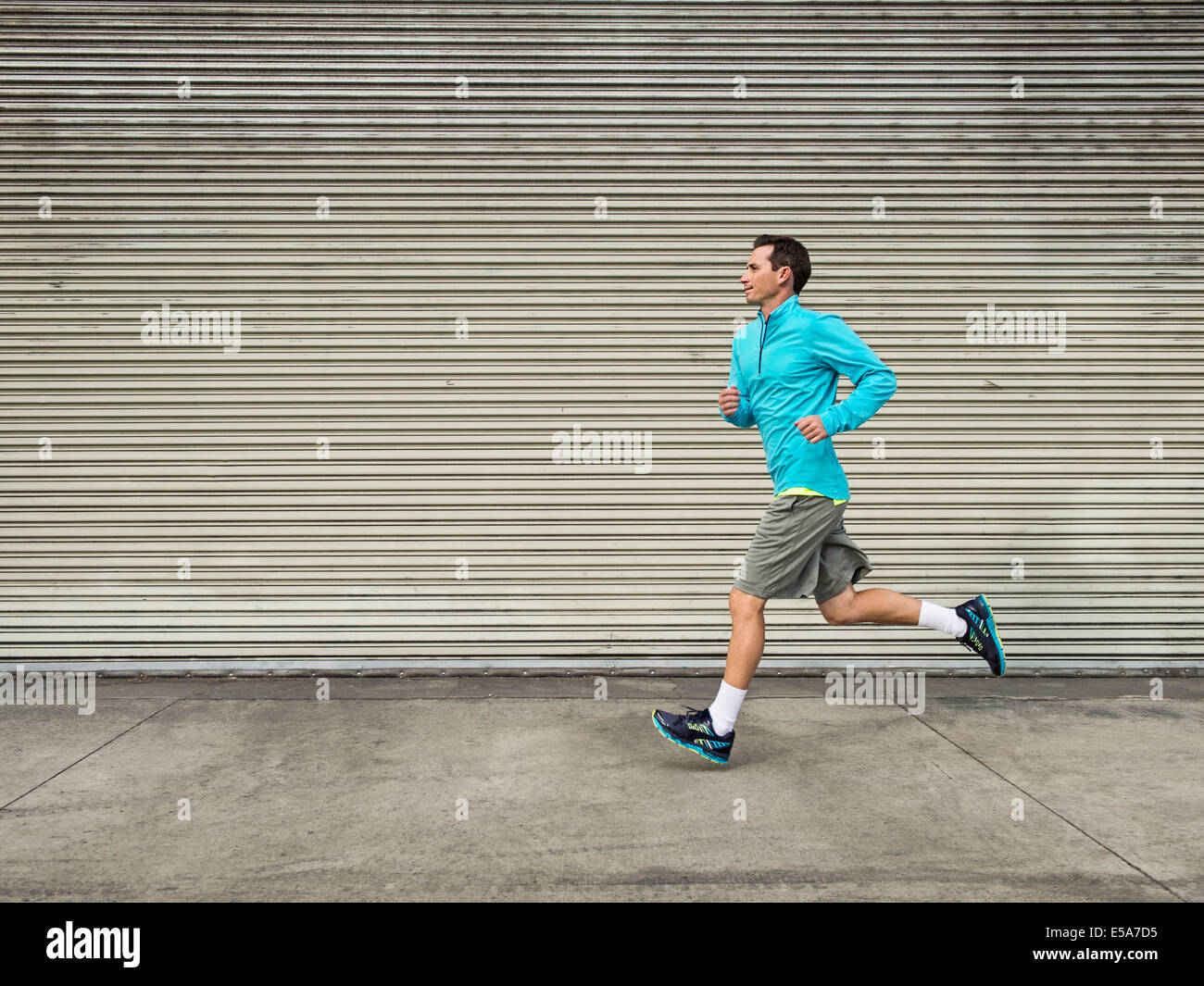 Caucasian man running on city street Stock Photo