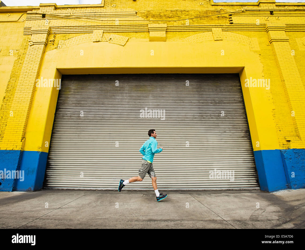 Caucasian man running on city street Stock Photo