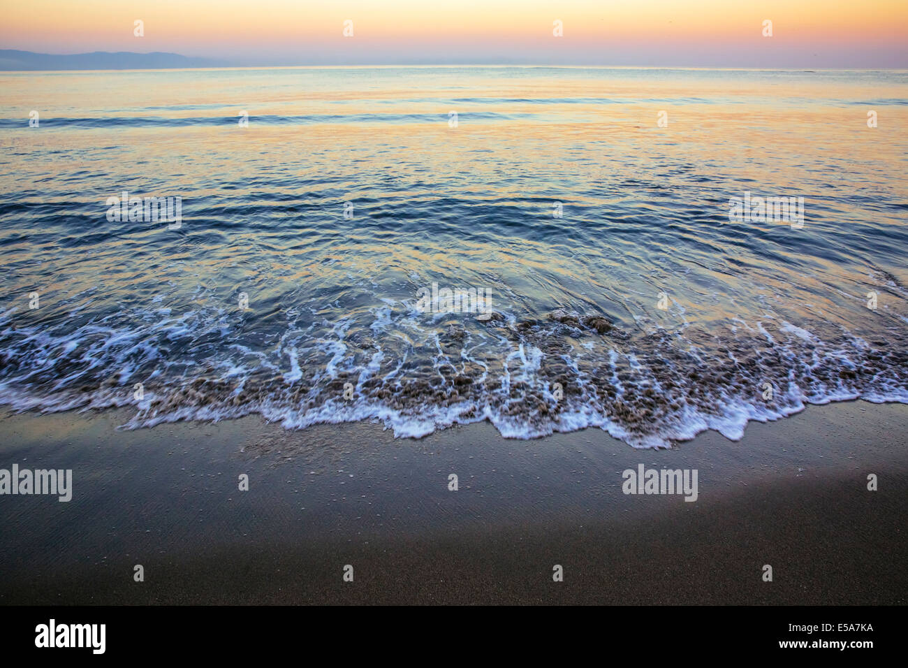 Waves washing up on sandy beach Stock Photo - Alamy