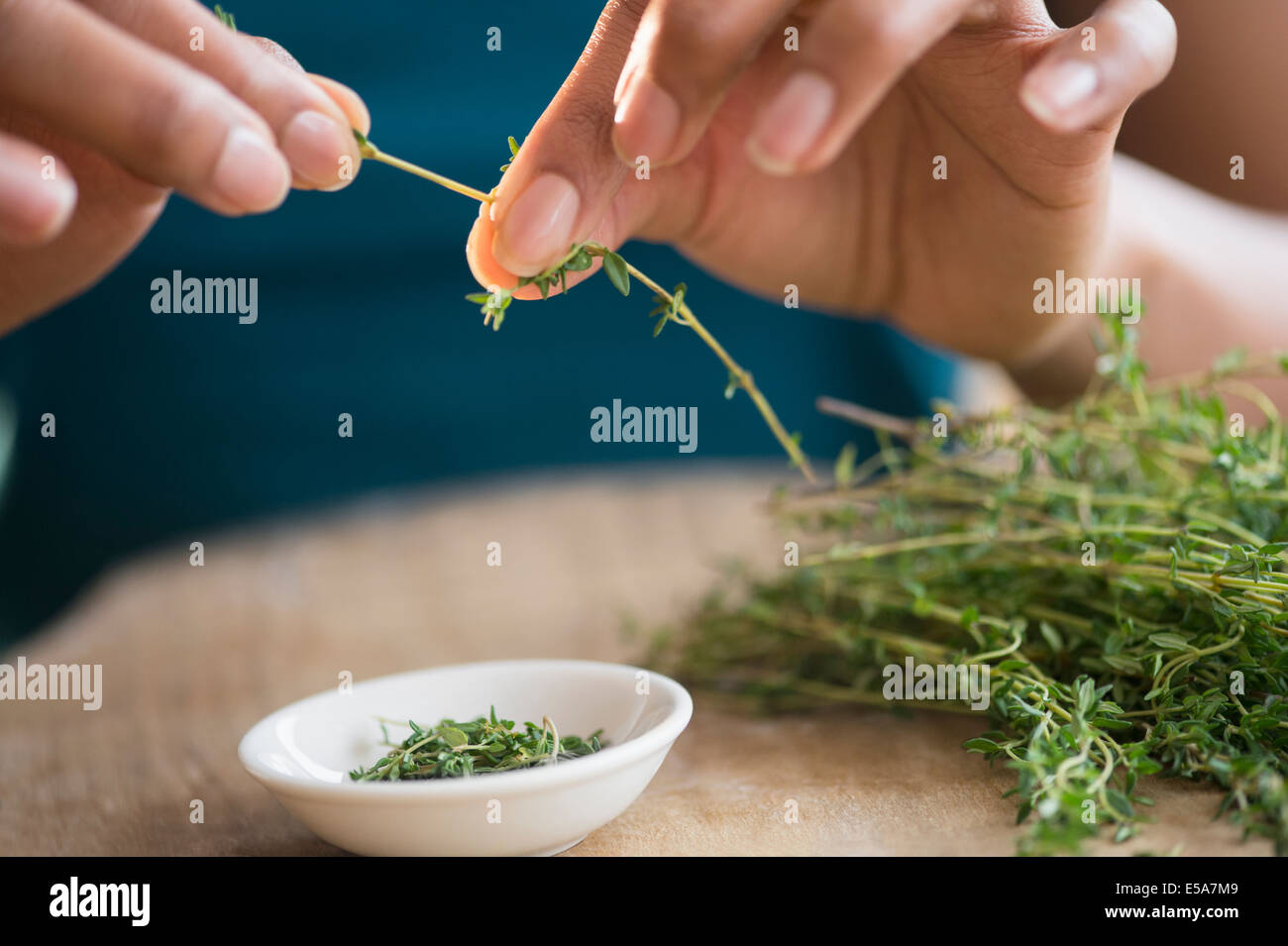 Mixed race woman trimming herbs Stock Photo