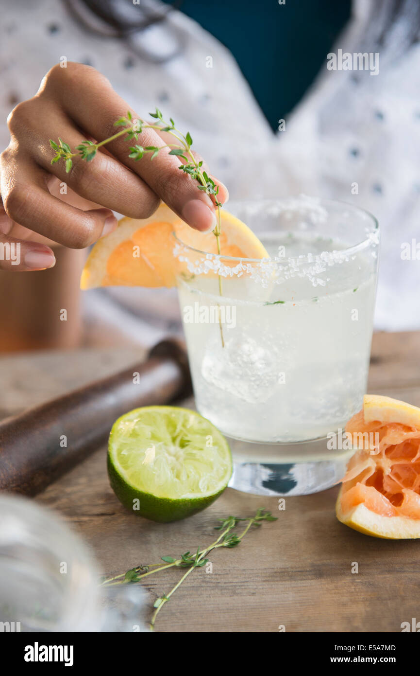 Mixed race woman making cocktail Stock Photo