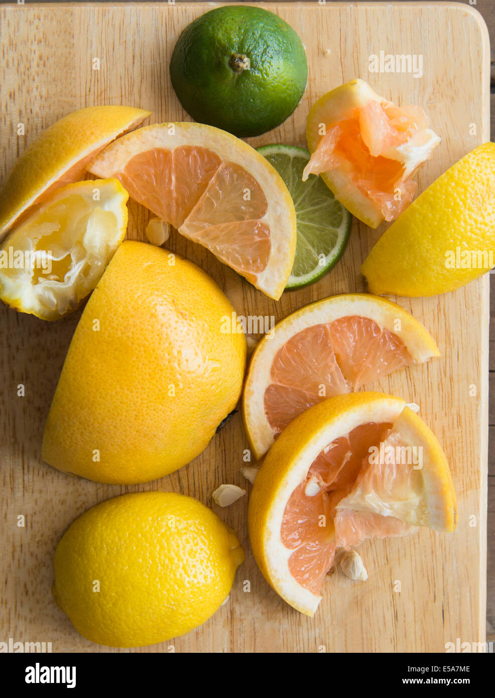 Sliced and squeezed fruit on wooden board Stock Photo