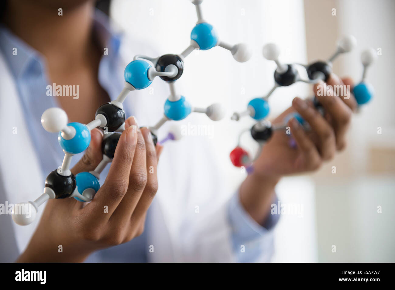 Mixed race scientist examining molecular model Stock Photo