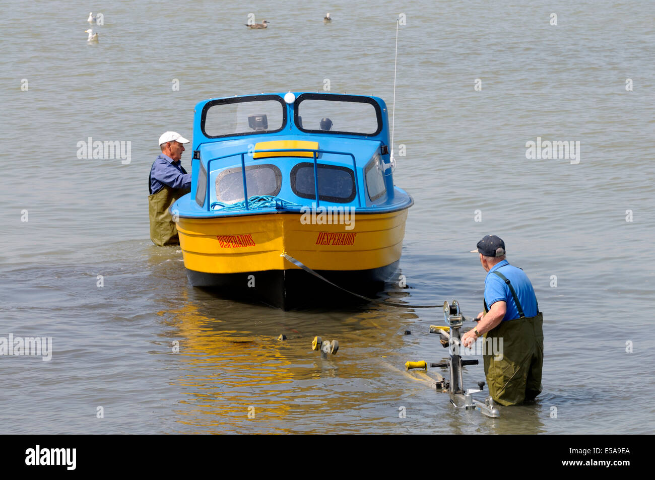 Margate, Kent, England, UK. Two men winching a small boat onto a