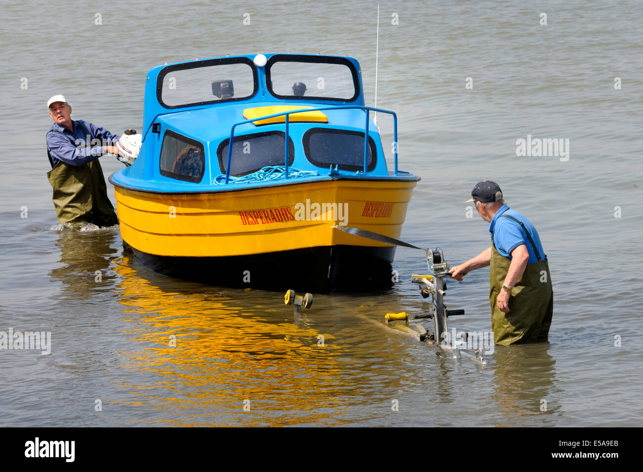 Margate, Kent, England, UK. Two men winching a small boat onto a trailer Stock Photo